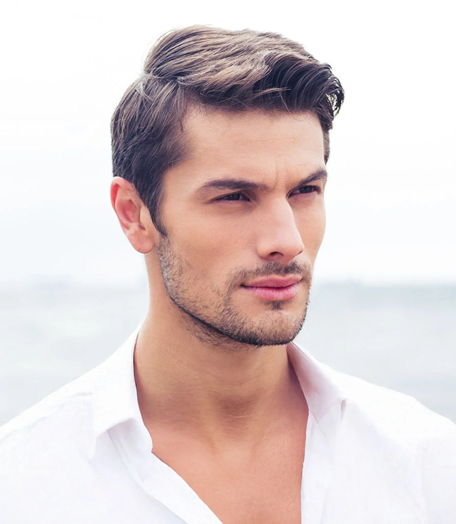 A man with a well-defined jawline and styled dark hair wearing a white shirt, looking off-camera.